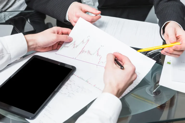 close-up-two-businesspeople-analyzing-report-office_23-2147838557