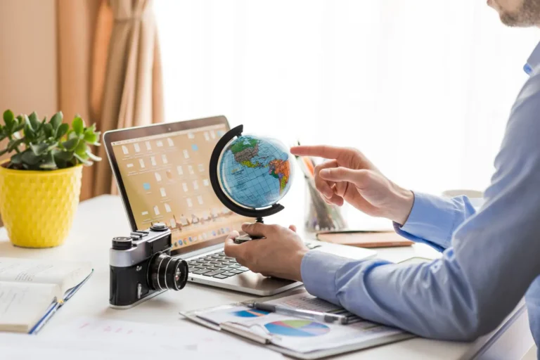crop-man-pointing-globe-office_23-2147772278